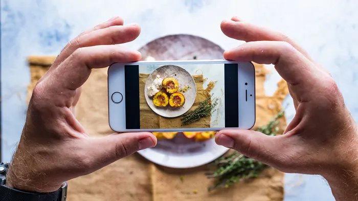 Persona fotografiando un plato de comida con el móvil